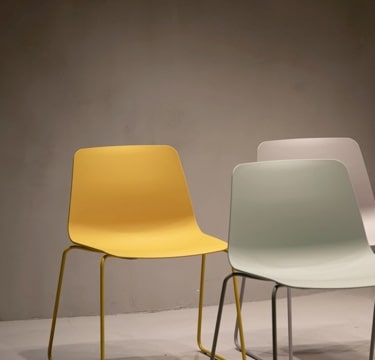three chairs, one yellow and 2 white.